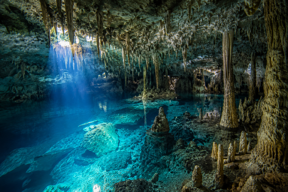 Crystal clear cenote cave with stalactites and limestone formations in Tulum Mexico